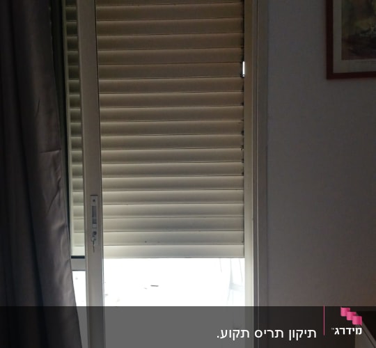 תריסים חומים חצי סגורים על דלת זכוכית